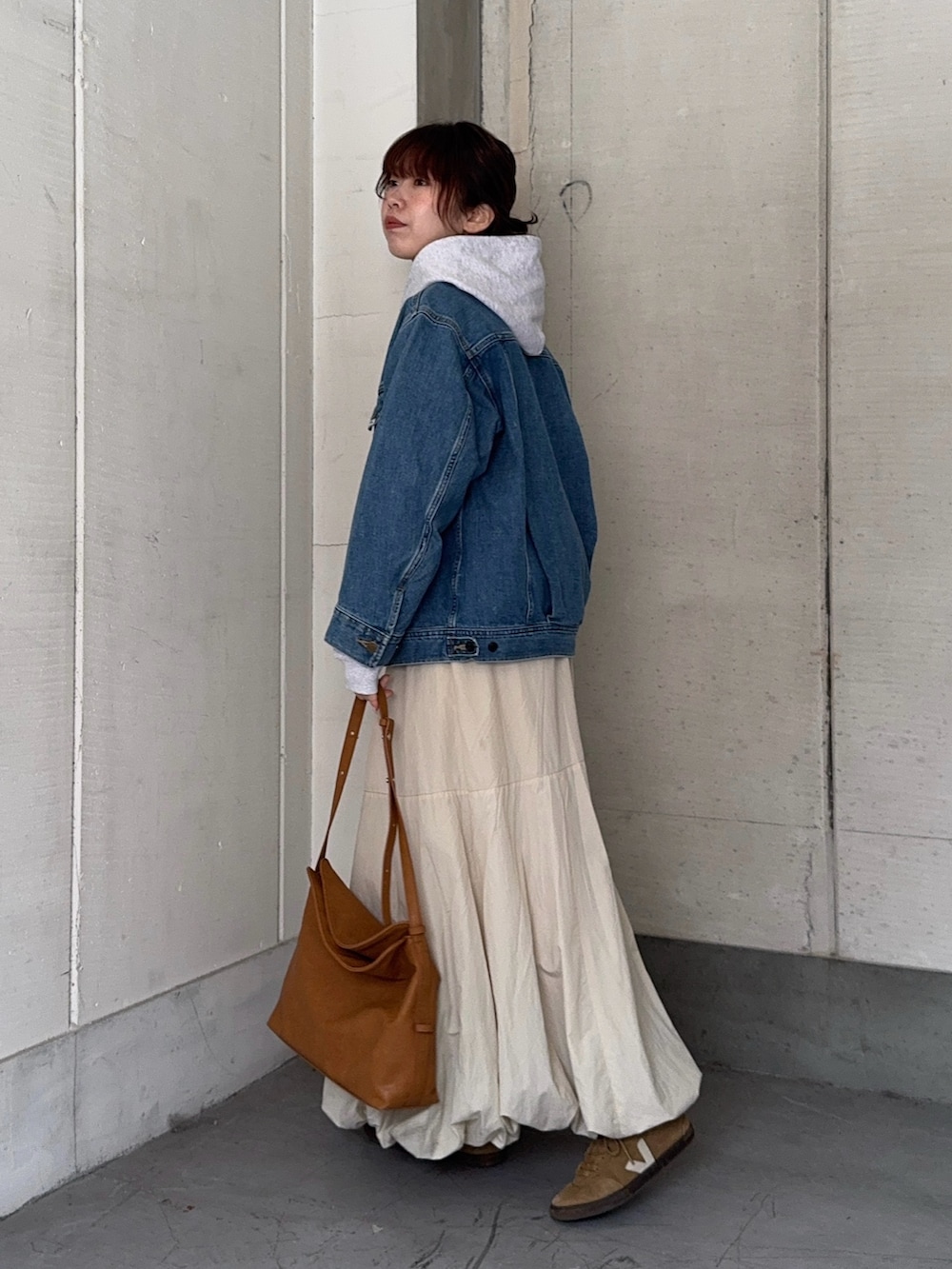 ブルー系のデニムジャケット、ベージュ系のショルダーバッグ、その他のパーカーを着用したレディースの冬コーディネートの2枚目の写真