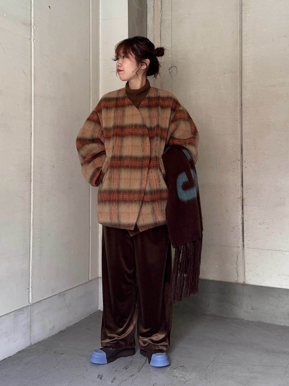 ベージュ系のノーカラージャケット、ブラウン系のニット/セーター、ブラウン系のサロペット/オーバーオールを着用したレディースの冬コーディネートの3枚目の写真