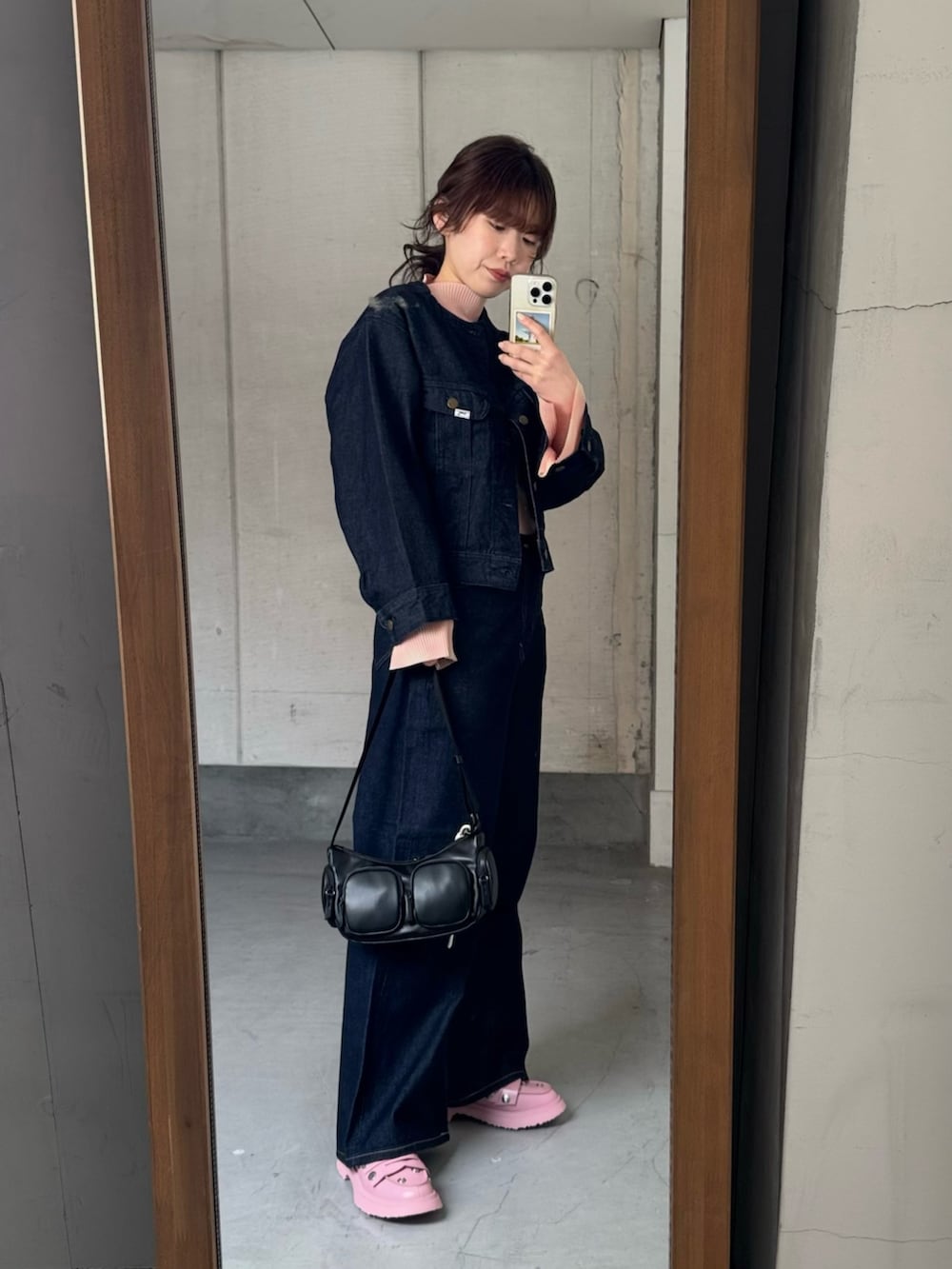 ブルー系のデニムジャケット、ブルー系のデニムパンツ、ブラック系のショルダーバッグを着用したレディースの冬コーディネートの6枚目の写真