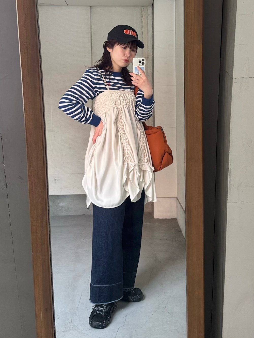 ブルー系のスウェット、ブルー系のデニムパンツ、ブラック系のスニーカーを着用したレディースの春コーディネートの4枚目の写真