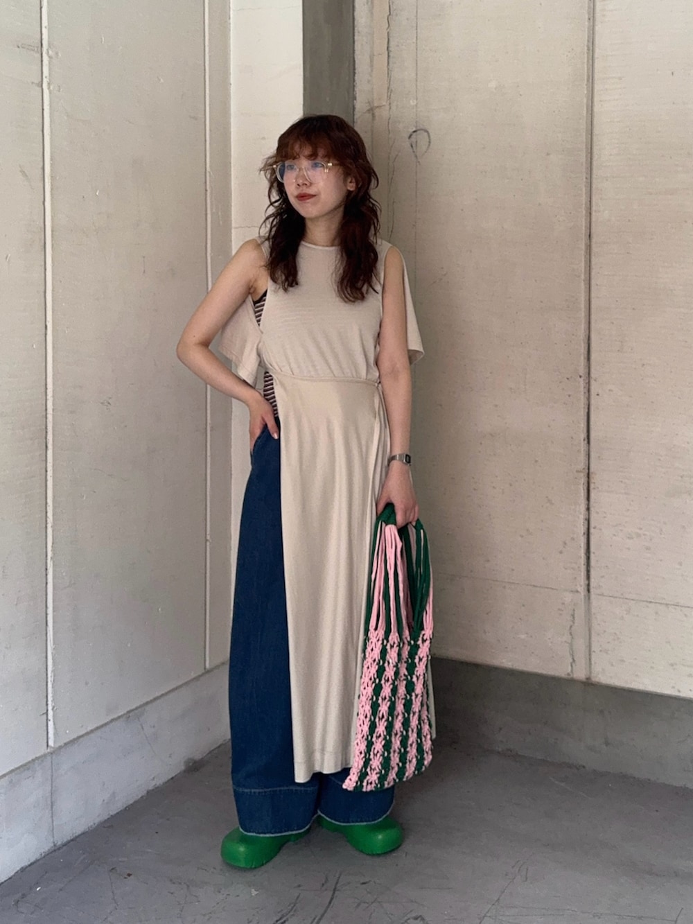 ホワイト系のワンピース、ブルー系のデニムパンツ、グリーン系のスリッポンを着用したレディースの夏コーディネートの2枚目の写真