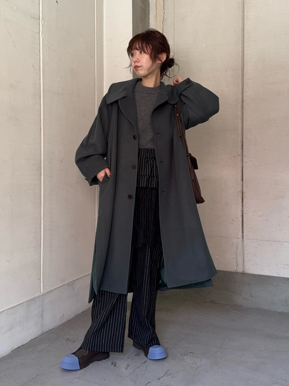 グリーン系のステンカラーコート、ブラック系のその他パンツ、ブラウン系のショルダーバッグを着用したレディースの秋コーディネートの4枚目の写真