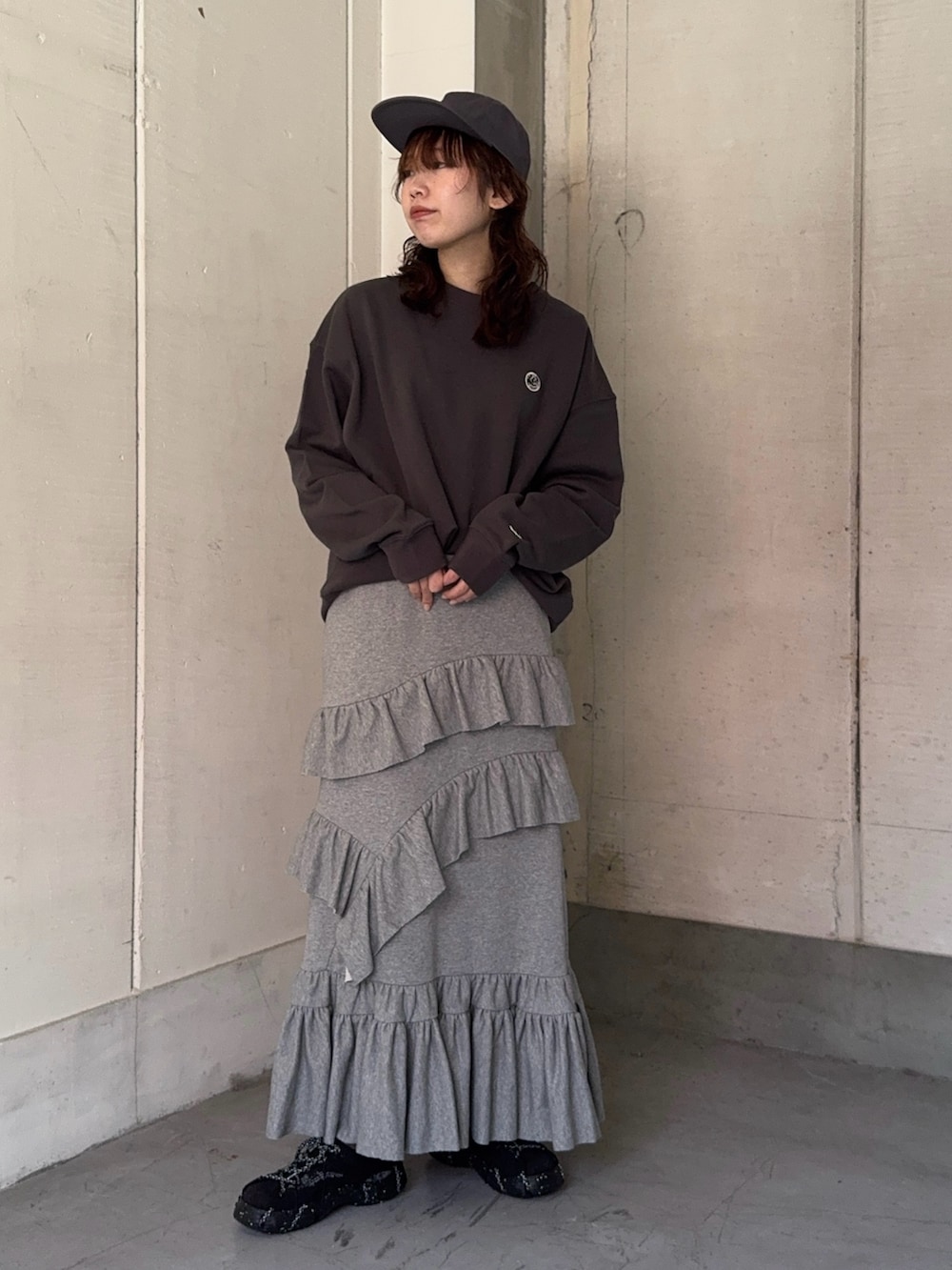 グレー系のスウェット、グレー系のスカート、ホワイト系のトートバッグを着用したレディースの冬コーディネートの4枚目の写真