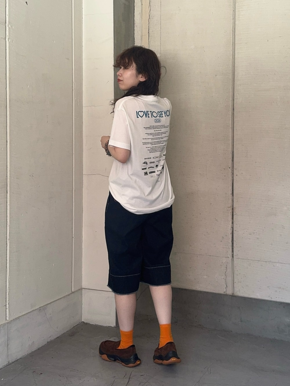 ブルー系のデニムパンツ、ブラウン系のローファーを着用したレディースの夏コーディネートの2枚目の写真