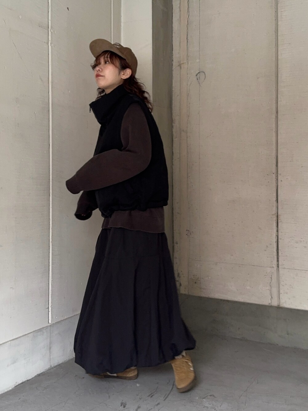 ベージュ系のスニーカー、ブラウン系のキャップを着用したレディースの冬コーディネートの2枚目の写真