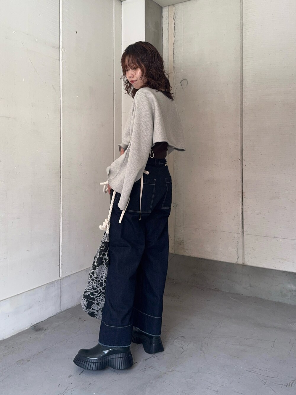 ブルー系のデニムパンツ、その他のトートバッグ、グリーン系のブーツを着用したレディースの秋コーディネートの3枚目の写真