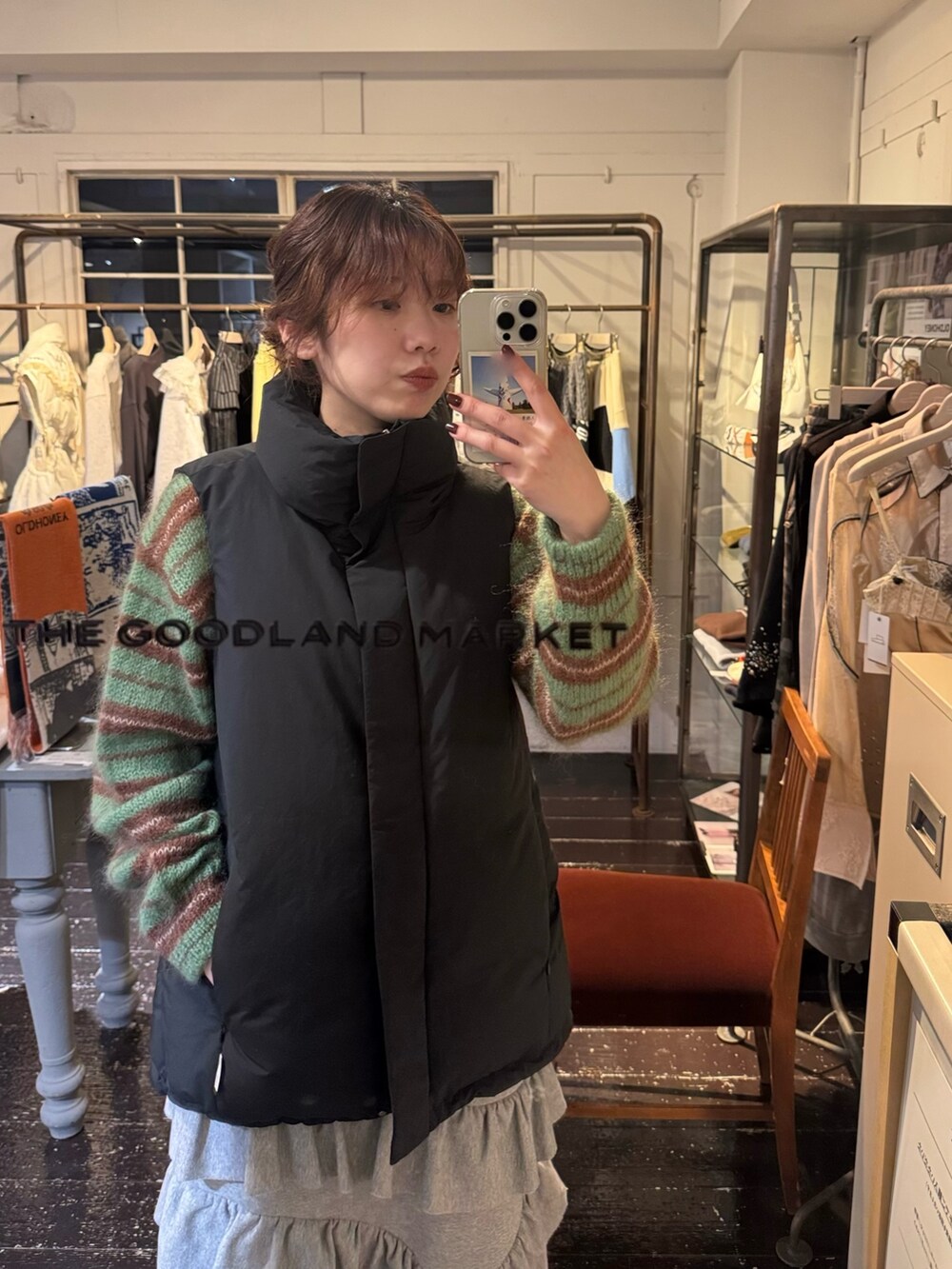 グレー系のスカート、ホワイト系のスニーカー、グリーン系のニット/セーターを着用したレディースの冬コーディネートの2枚目の写真