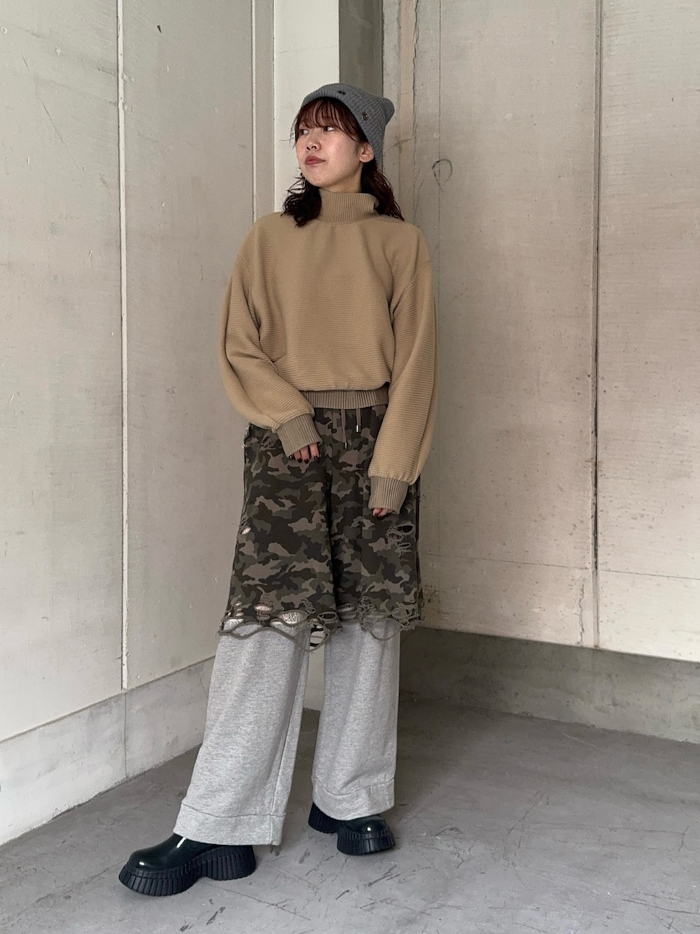 ベージュ系のTシャツ/カットソー、グリーン系のブーツを着用したレディースの秋コーディネートの2枚目の写真