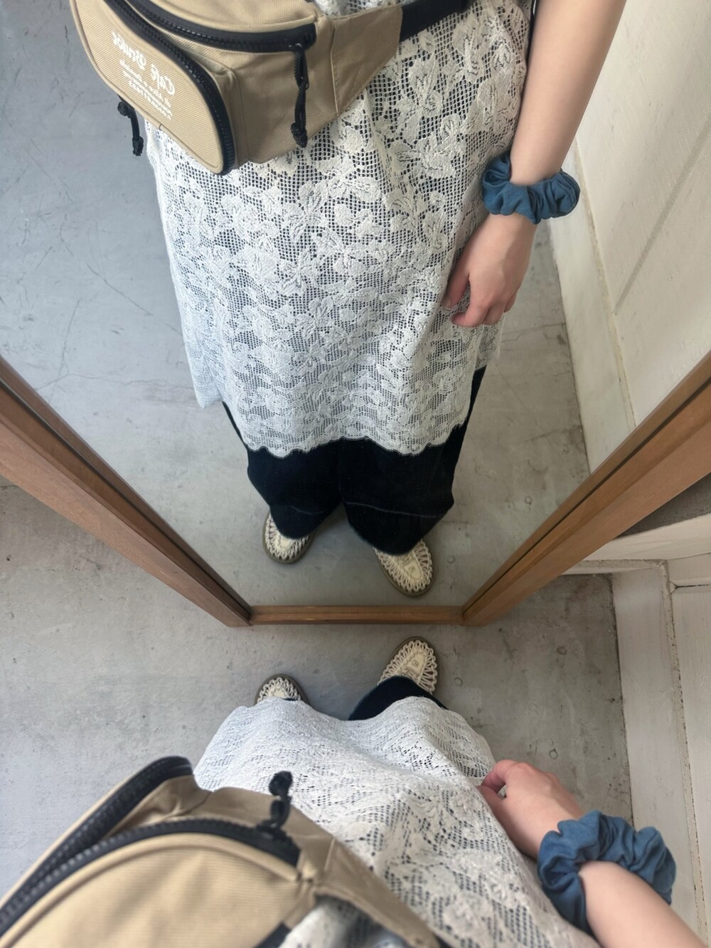 ホワイト系のスカート、ブルー系のデニムパンツ、ホワイト系のサンダルを着用したレディースの夏コーディネートの5枚目の写真