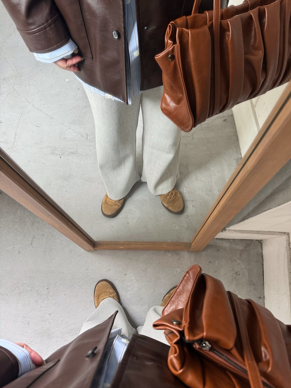 ブラウン系のその他アウター、ブルー系のシャツ/ブラウス、ブラウン系のトートバッグを着用したレディースの春コーディネートの3枚目の写真