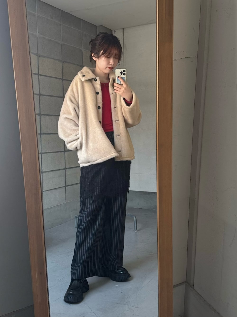 ブラック系のテーラードジャケット、レッド系のカーディガン/ボレロ、ブラック系のその他パンツを着用したレディースの冬コーディネートの5枚目の写真