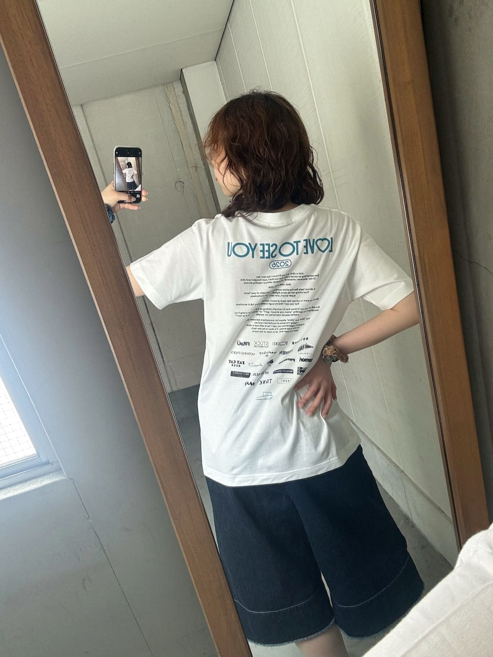 ブルー系のデニムパンツ、ブラウン系のローファーを着用したレディースの夏コーディネートの3枚目の写真