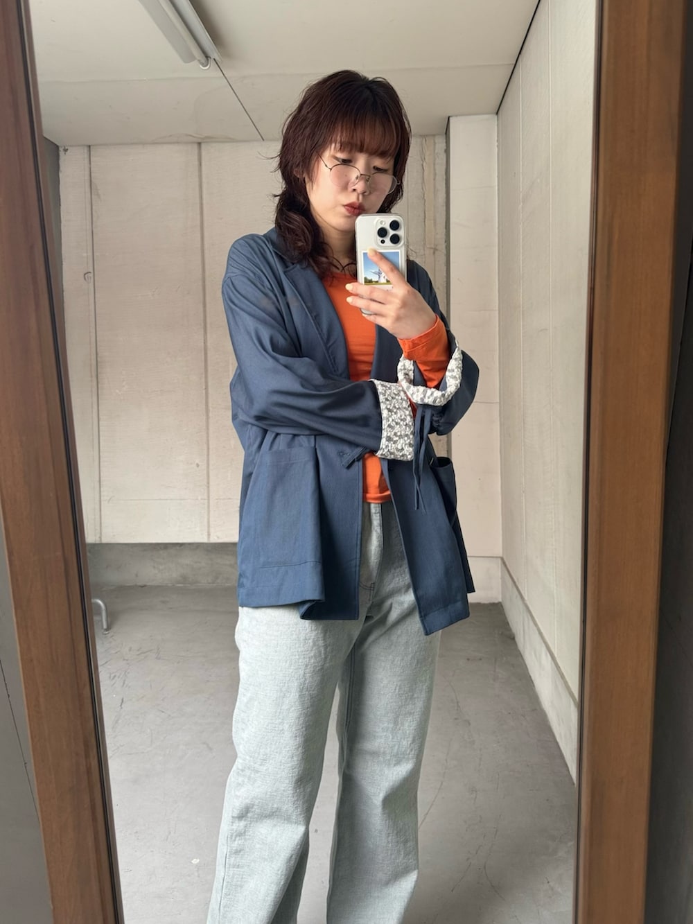 ブルー系のテーラードジャケット、オレンジ系のTシャツ/カットソー、ブルー系のデニムパンツを着用したレディースの冬コーディネートの6枚目の写真