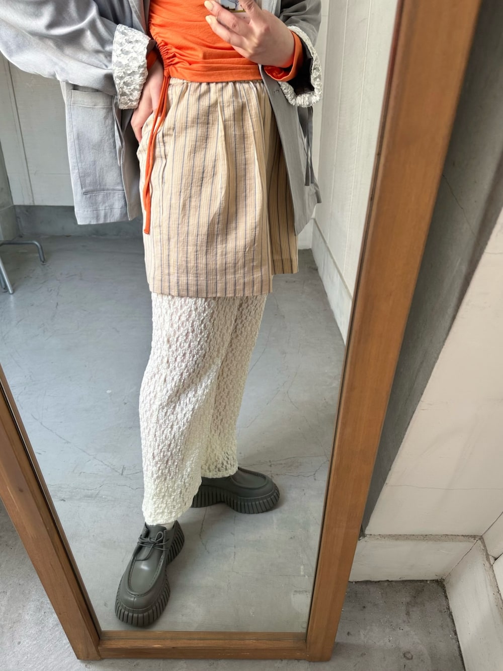 オレンジ系のその他パンツ、オレンジ系のTシャツ/カットソー、グレー系のその他アウターを着用したレディースの冬コーディネートの3枚目の写真