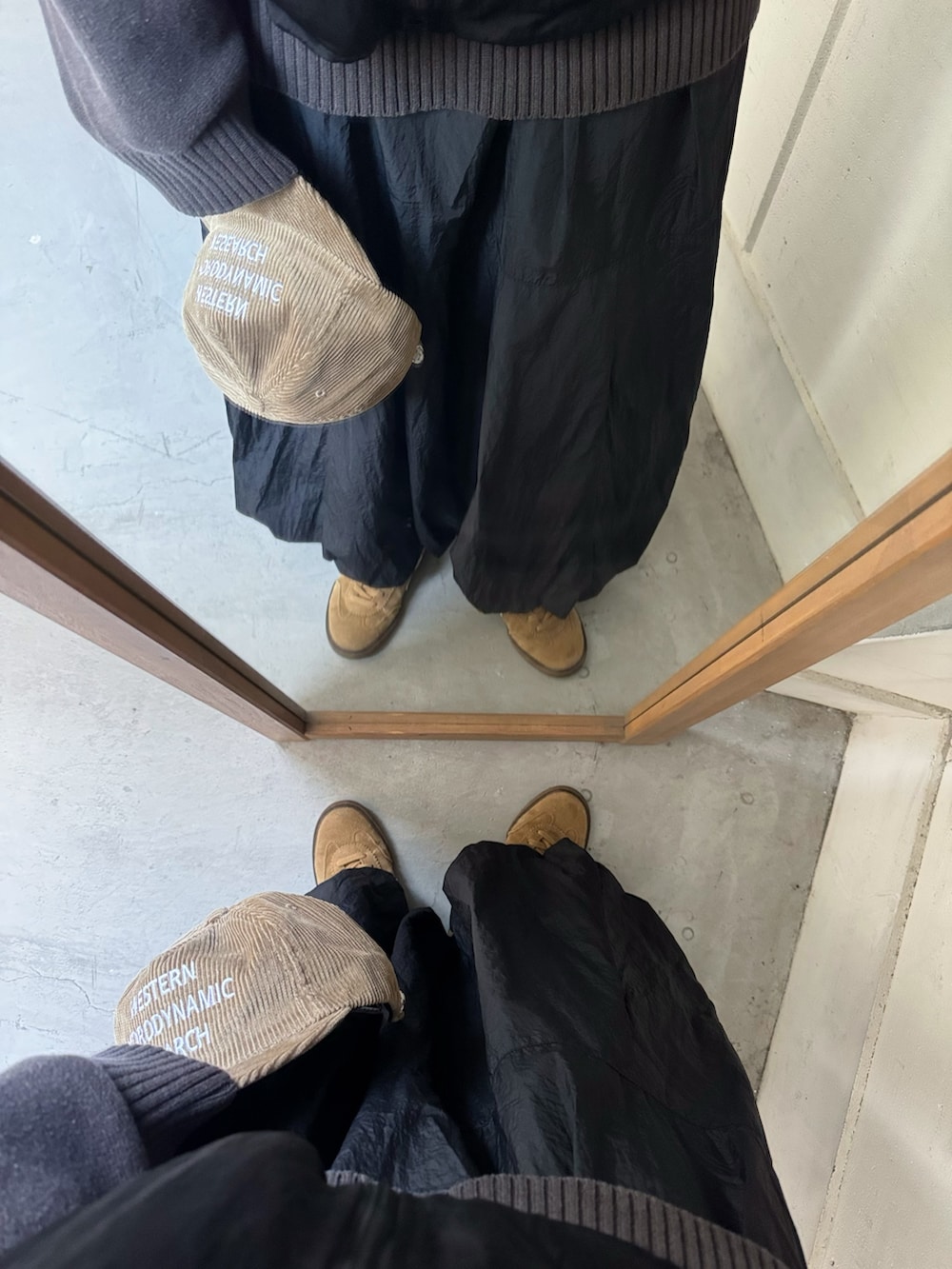 ベージュ系のスニーカー、ブラウン系のキャップを着用したレディースの冬コーディネートの3枚目の写真