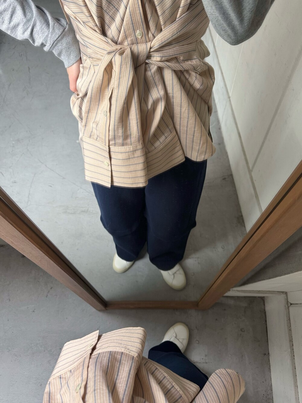 オレンジ系のシャツ/ブラウス、ブルー系のその他パンツ、ホワイト系のスニーカーを着用したレディースの春コーディネートの3枚目の写真