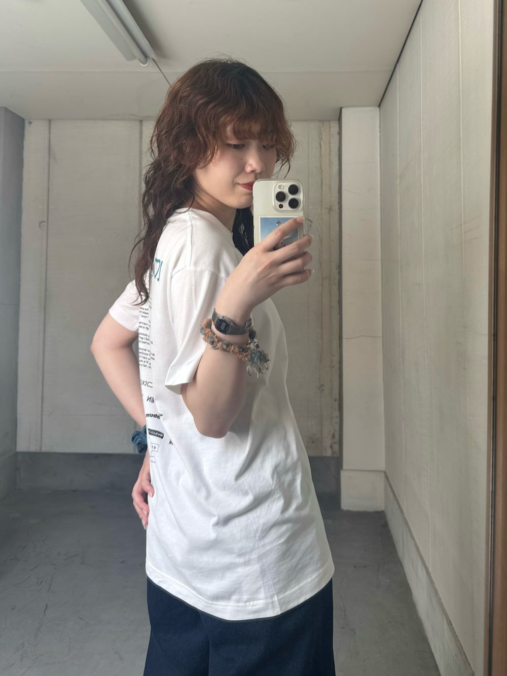 ブルー系のデニムパンツ、ブラウン系のローファーを着用したレディースの夏コーディネートの4枚目の写真
