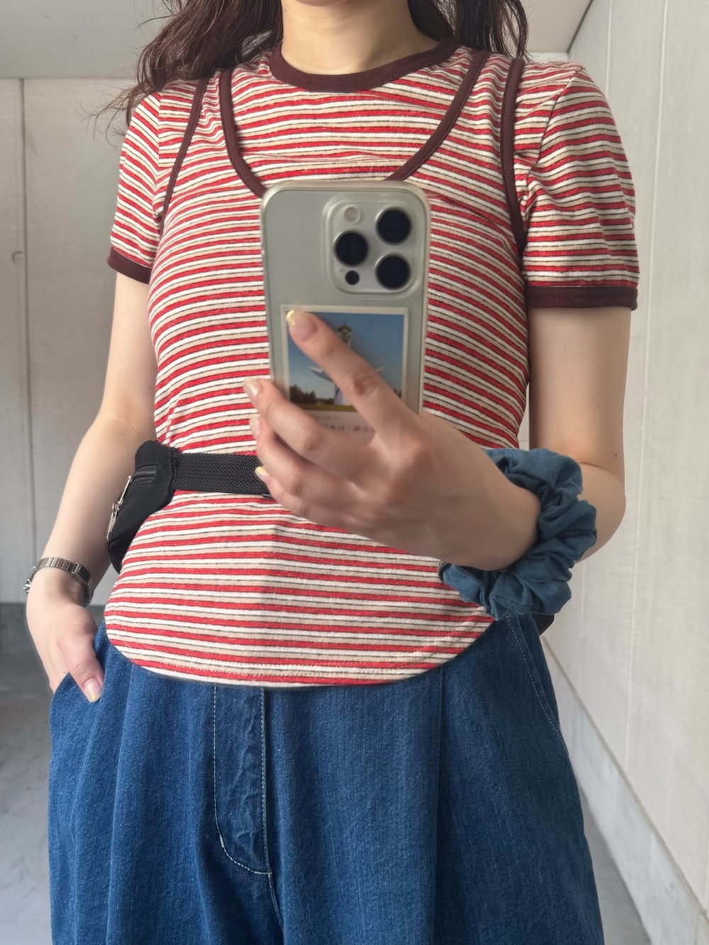 レッド系のTシャツ/カットソー、レッド系のタンクトップ、ブルー系のデニムパンツを着用したレディースの夏コーディネートの2枚目の写真