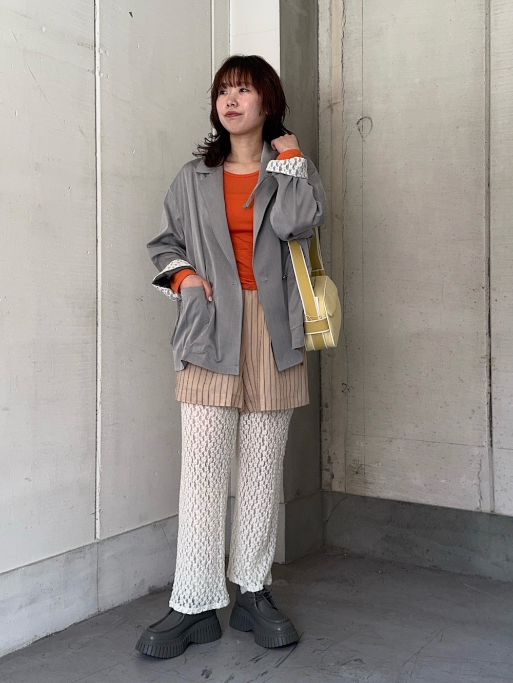 オレンジ系のその他パンツ、オレンジ系のTシャツ/カットソー、グレー系のその他アウターを着用したレディースの冬コーディネートの6枚目の写真