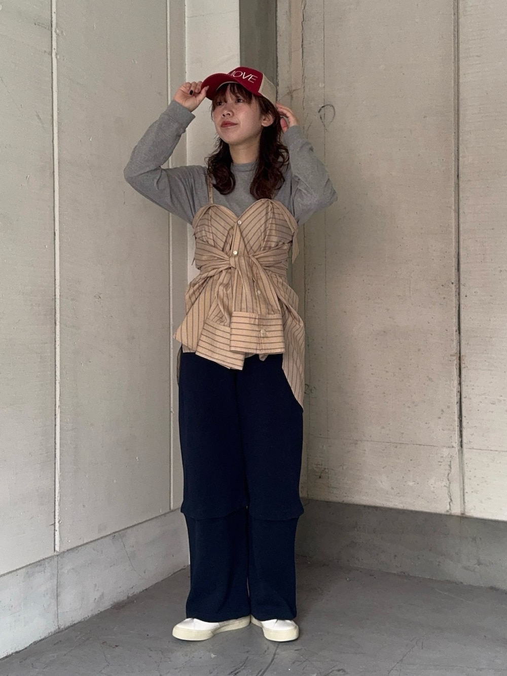 オレンジ系のシャツ/ブラウス、ブルー系のその他パンツ、ホワイト系のスニーカーを着用したレディースの春コーディネートの4枚目の写真