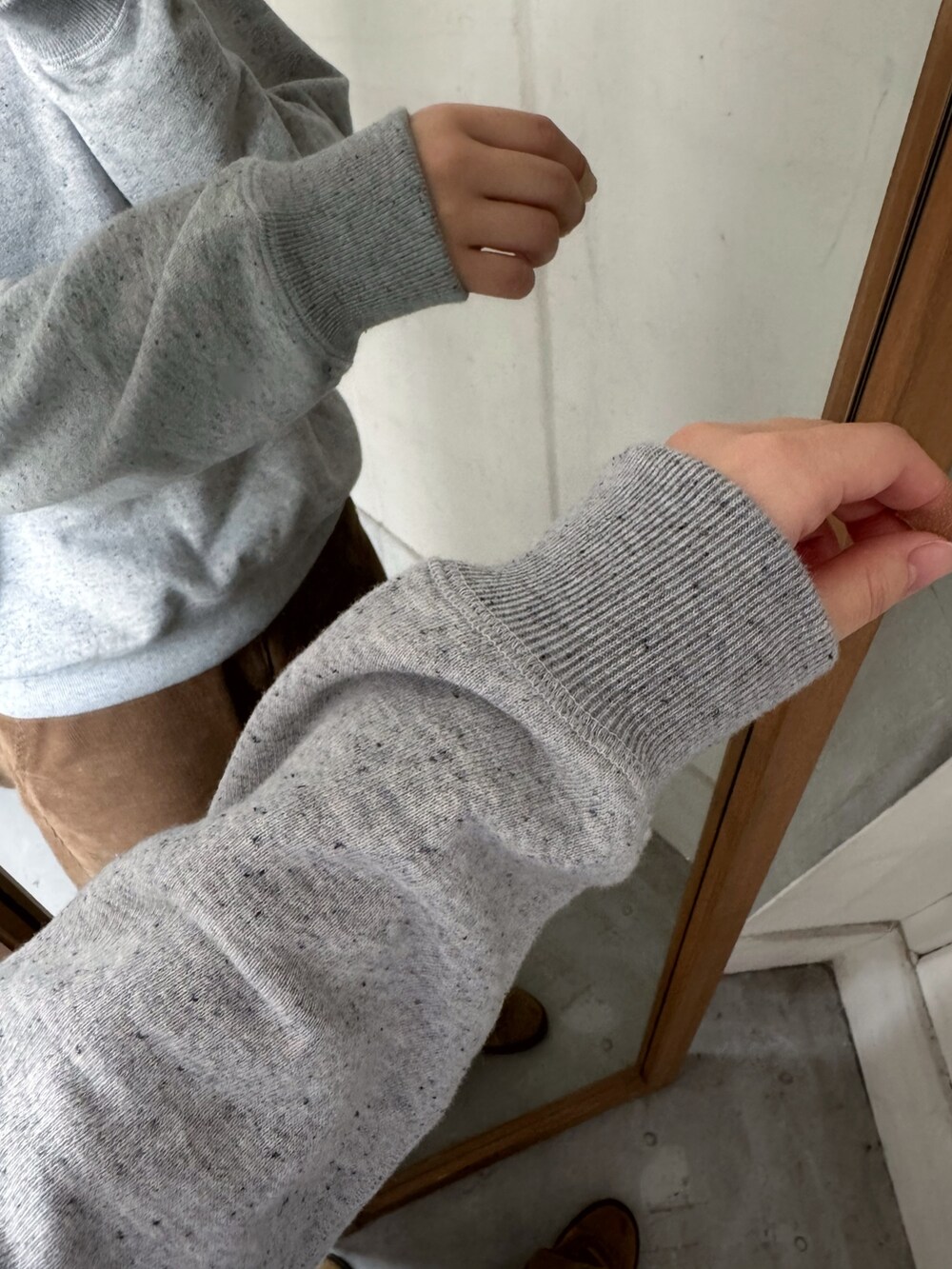 ベージュ系のスニーカー、グレー系のスウェット、その他のベストを着用したレディースの秋コーディネートの6枚目の写真