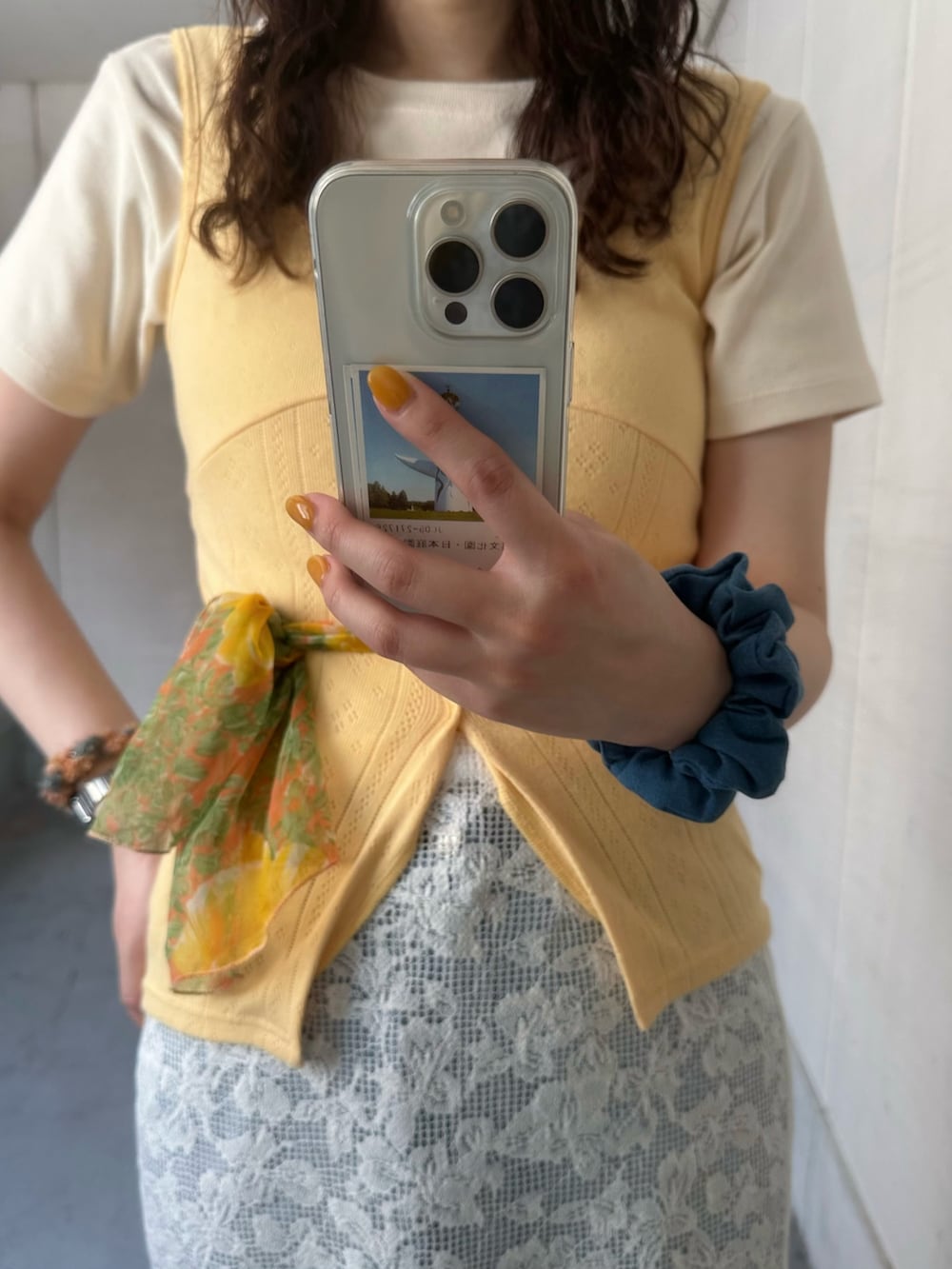 ホワイト系のスカート、オレンジ系のサンダル、イエロー系のタンクトップを着用したレディースの夏コーディネートの3枚目の写真