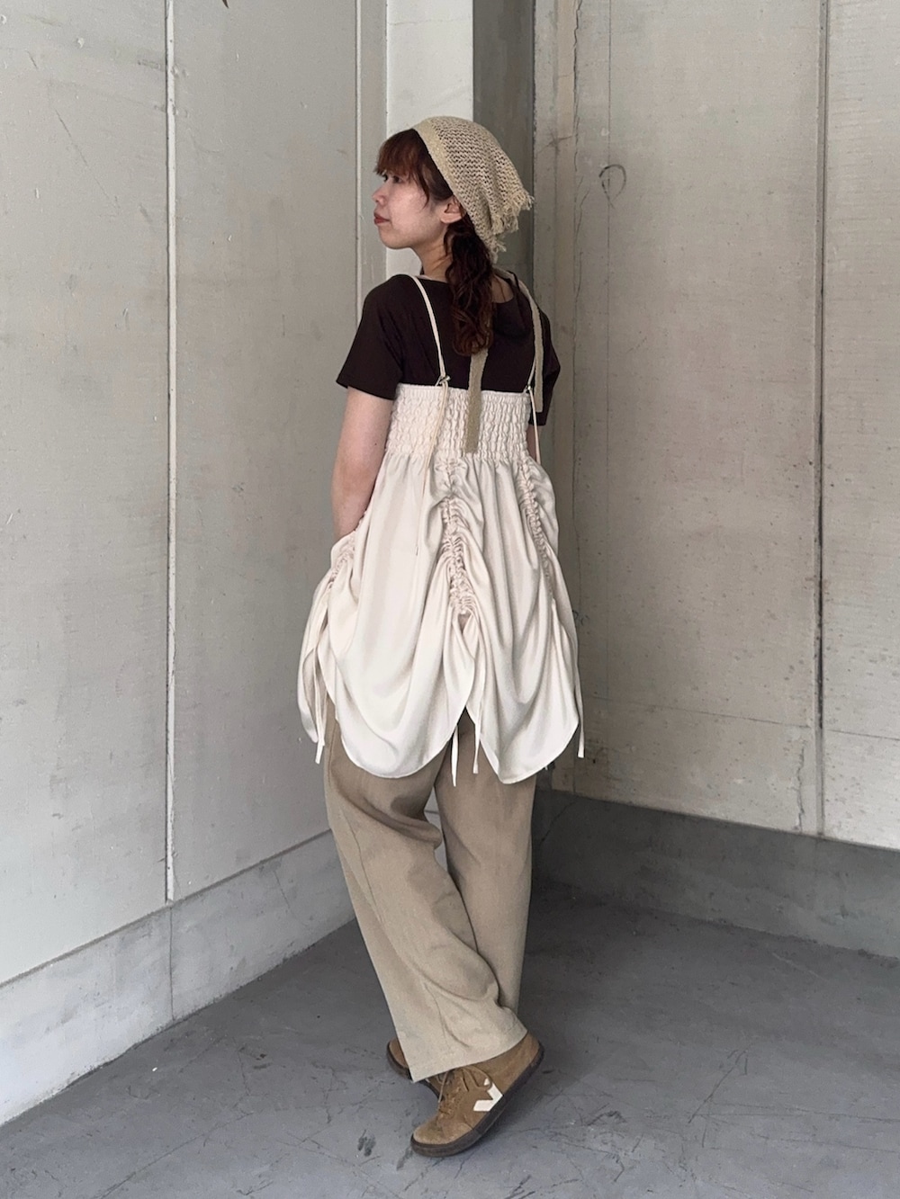 ブラウン系のTシャツ/カットソー、ベージュ系のスニーカー、ホワイト系のワンピースを着用したレディースの春コーディネートの2枚目の写真