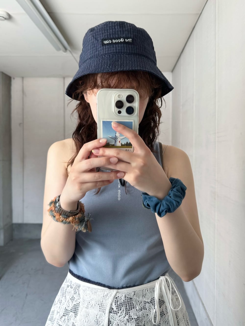 ブルー系のタンクトップ、ホワイト系のスカート、ブルー系のその他パンツを着用したレディースの夏コーディネートの3枚目の写真