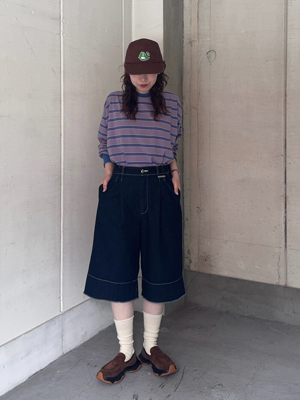 ブルー系のTシャツ/カットソー、ブルー系のデニムパンツ、ブラウン系のキャップを着用したレディースの夏コーディネートの2枚目の写真
