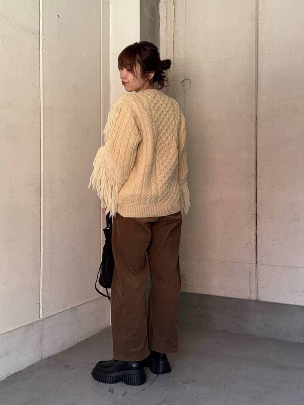 その他のニット/セーター、ブラック系のドレスシューズ、ブラック系のハンドバッグを着用したレディースの秋コーディネートの6枚目の写真