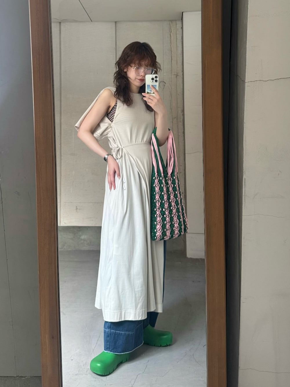 ホワイト系のワンピース、ブルー系のデニムパンツ、グリーン系のスリッポンを着用したレディースの夏コーディネートの5枚目の写真