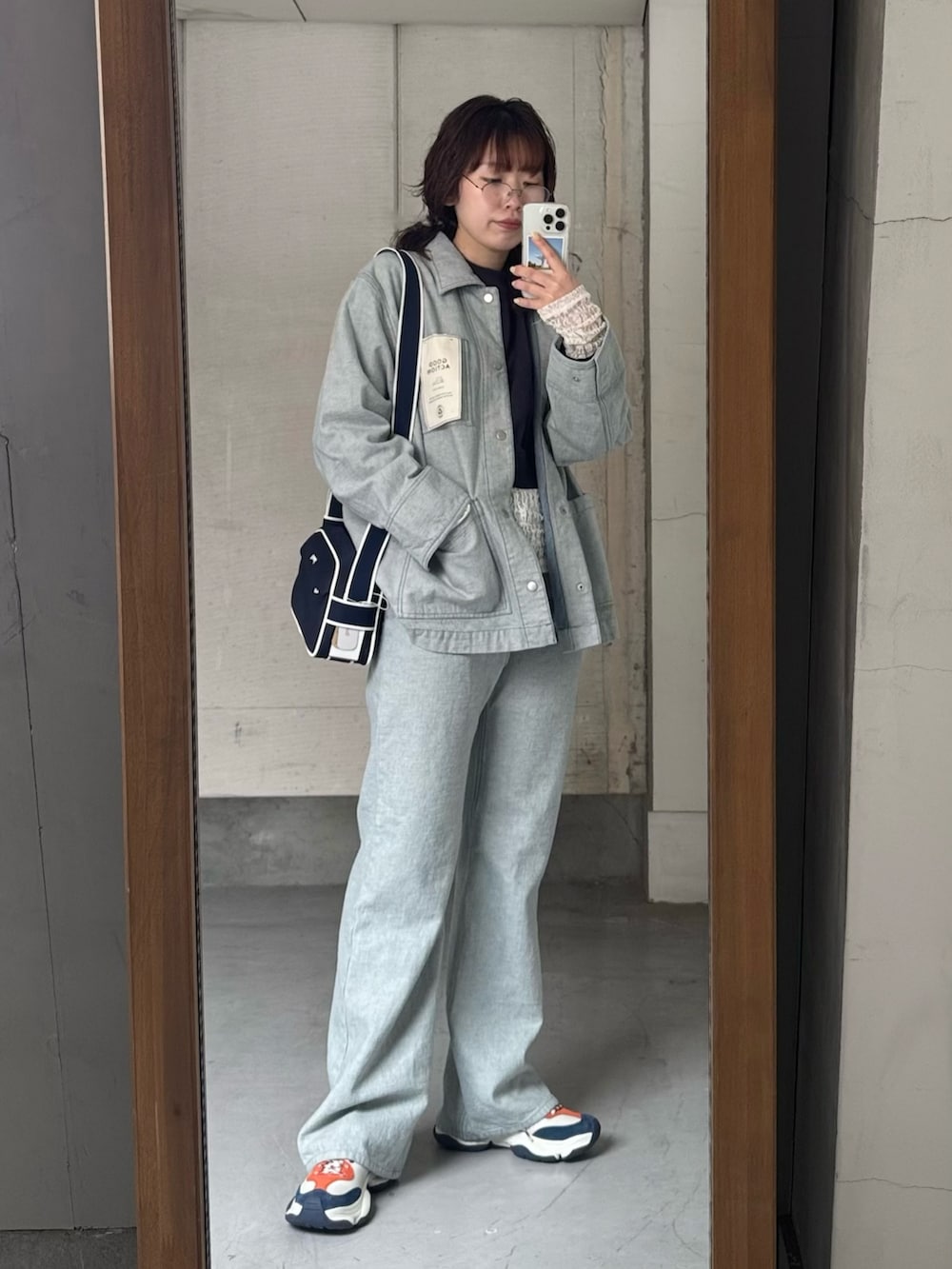 ブルー系のデニムジャケット、ブルー系のデニムパンツ、ホワイト系のスニーカーを着用したレディースの冬コーディネートの6枚目の写真