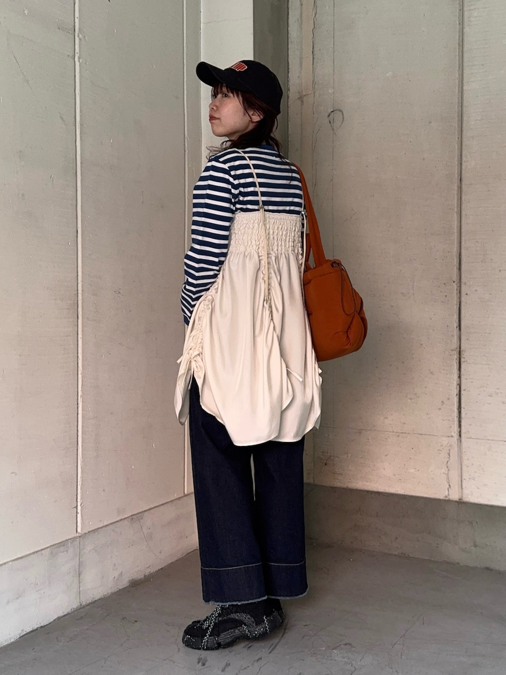 ブルー系のスウェット、ブルー系のデニムパンツ、ブラック系のスニーカーを着用したレディースの春コーディネートの2枚目の写真