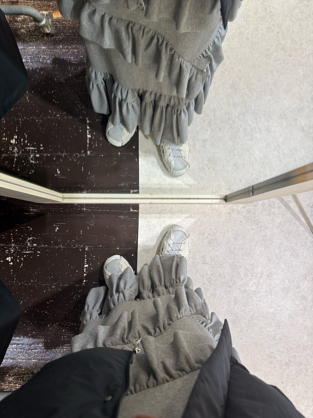 グレー系のスカート、ホワイト系のスニーカー、グリーン系のニット/セーターを着用したレディースの冬コーディネートの3枚目の写真