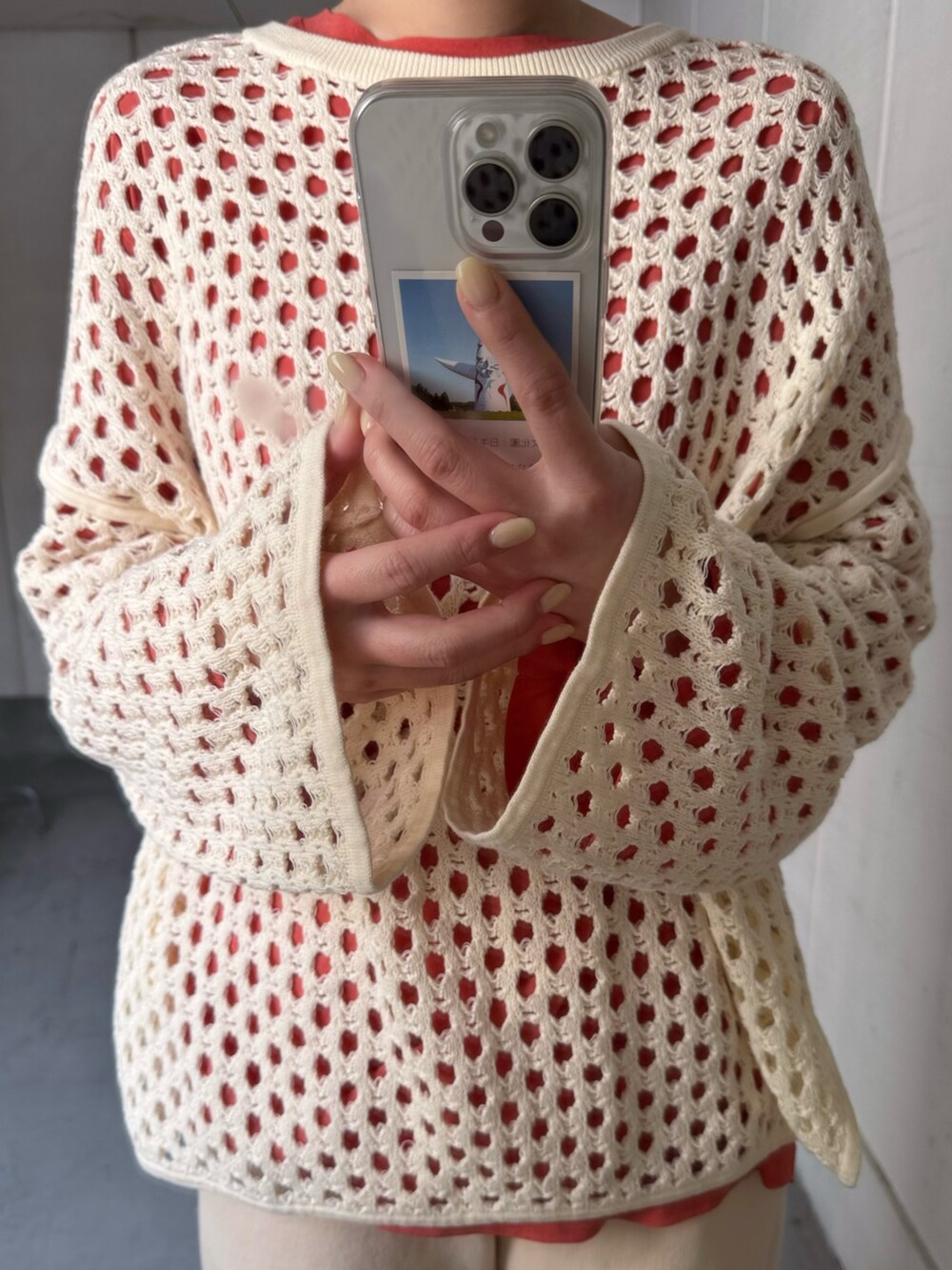 オレンジ系のTシャツ/カットソー、ホワイト系のその他パンツ、ホワイト系のスニーカーを着用したレディースの冬コーディネートの5枚目の写真