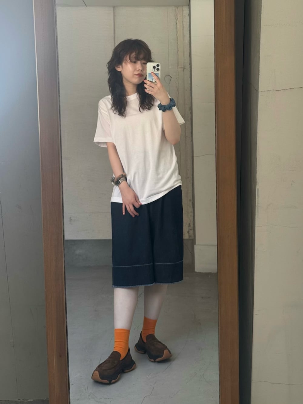 ブルー系のデニムパンツ、ブラウン系のローファーを着用したレディースの夏コーディネートの5枚目の写真