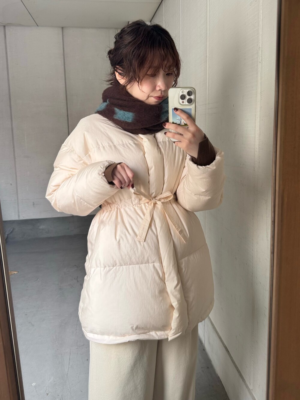 ブラウン系のスニーカー、ブラウン系のマフラーを着用したレディースの冬コーディネートの4枚目の写真