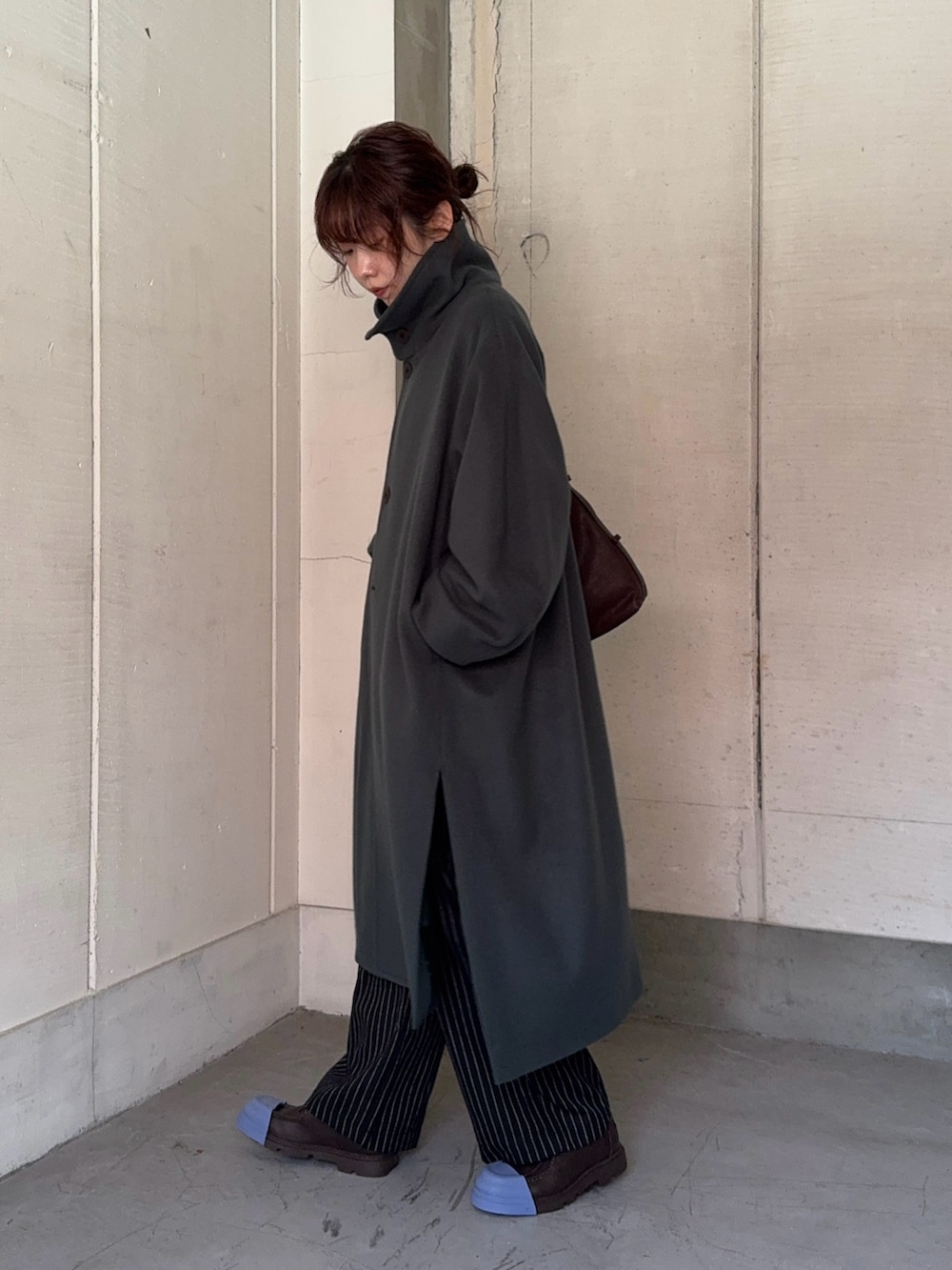 グリーン系のステンカラーコート、ブラック系のその他パンツ、ブラウン系のショルダーバッグを着用したレディースの秋コーディネートの6枚目の写真