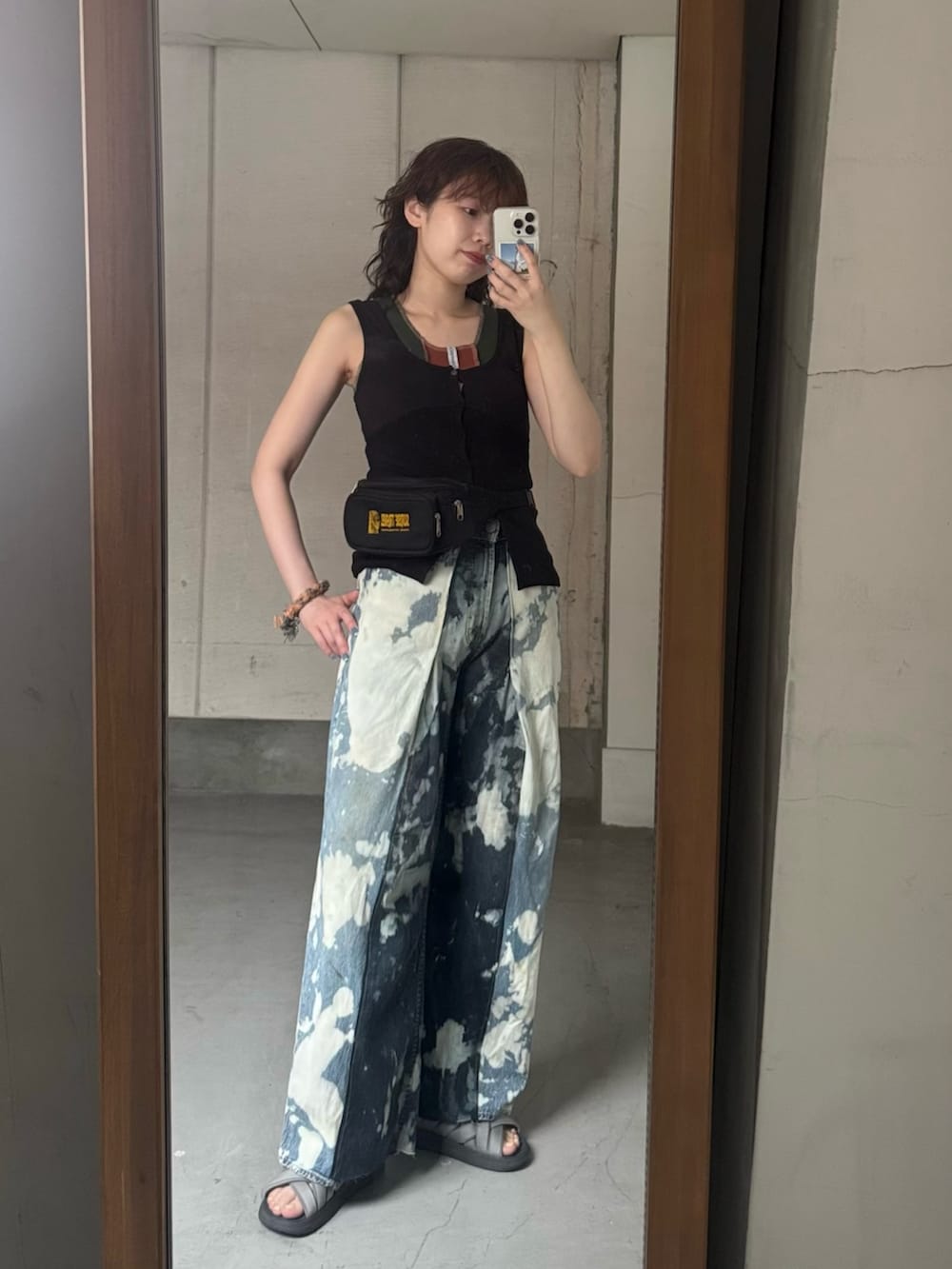 ブラック系のタンクトップ、グレー系のサンダルを着用したレディースの夏コーディネートの5枚目の写真