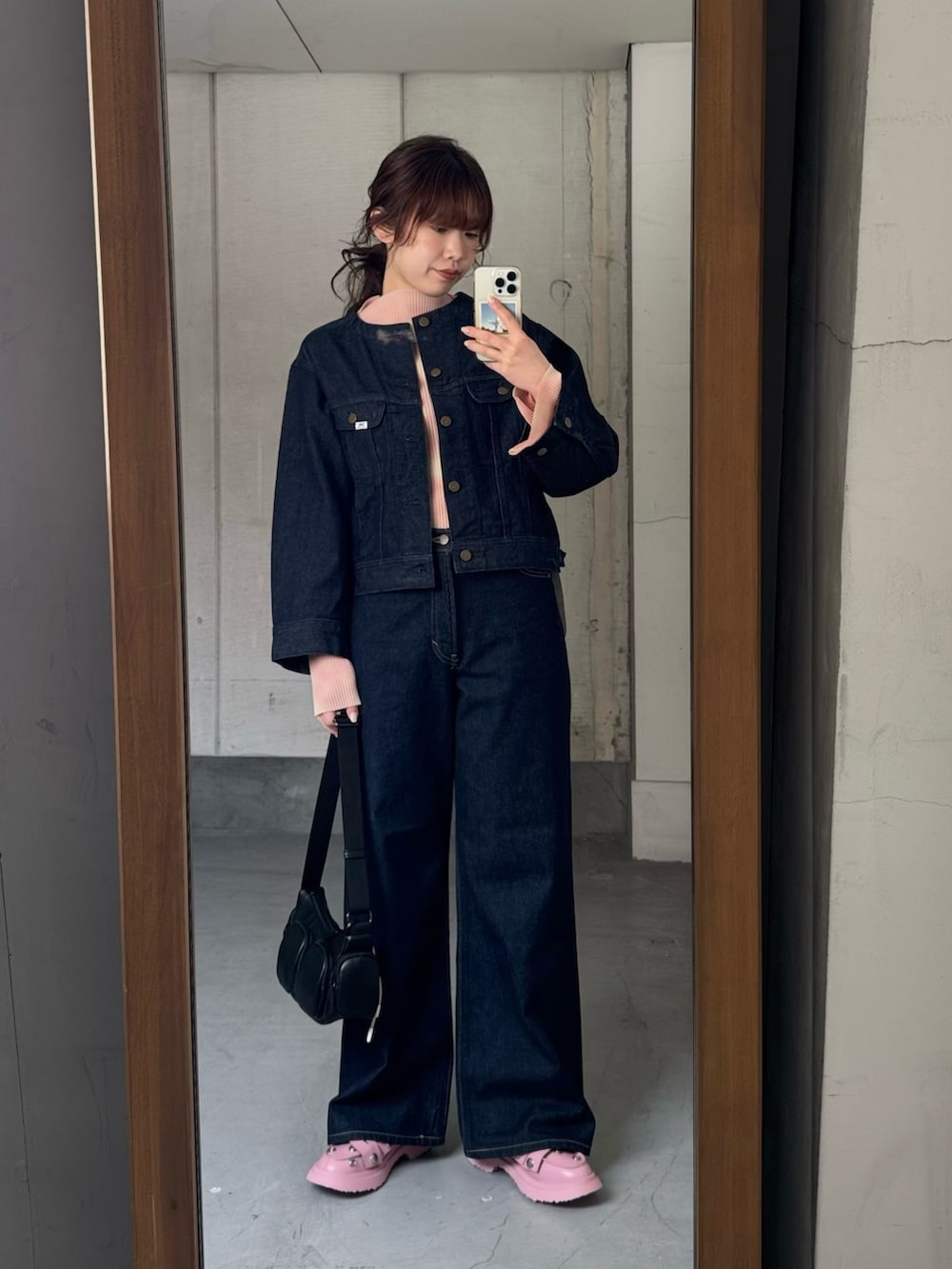 ブルー系のデニムジャケット、ブルー系のデニムパンツ、ブラック系のショルダーバッグを着用したレディースの冬コーディネートの5枚目の写真