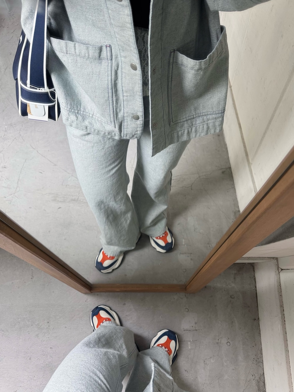 ブルー系のデニムジャケット、ブルー系のデニムパンツ、ホワイト系のスニーカーを着用したレディースの冬コーディネートの5枚目の写真