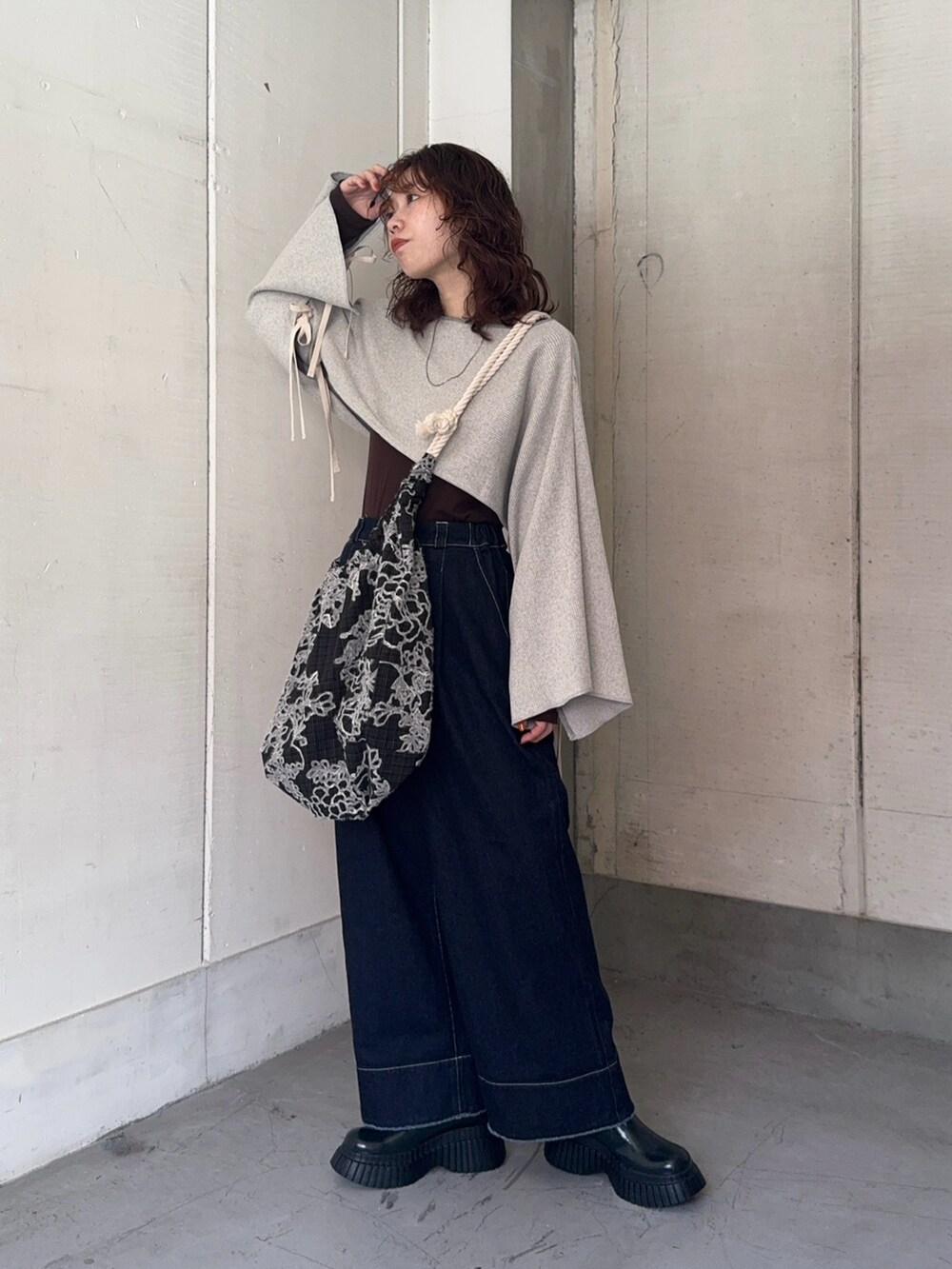 ブルー系のデニムパンツ、その他のトートバッグ、グリーン系のブーツを着用したレディースの秋コーディネートの2枚目の写真