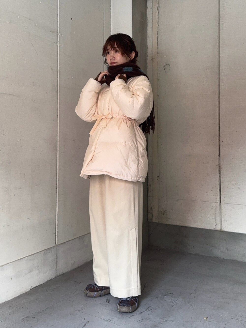 ブラウン系のスニーカー、ブラウン系のマフラーを着用したレディースの冬コーディネートの7枚目の写真