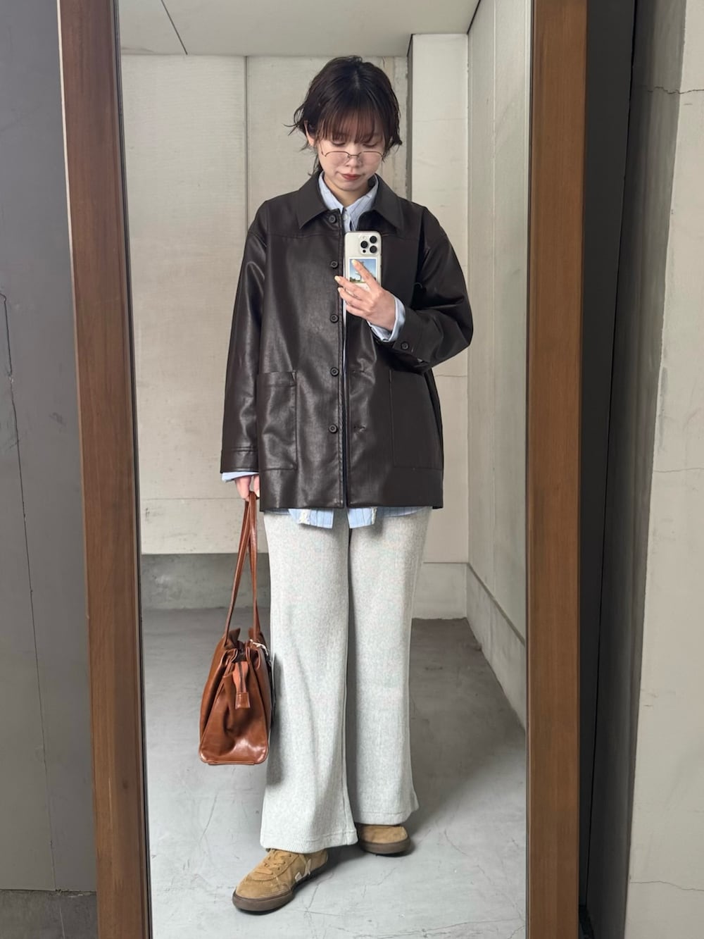 ブラウン系のその他アウター、ブルー系のシャツ/ブラウス、ブラウン系のトートバッグを着用したレディースの春コーディネートの2枚目の写真