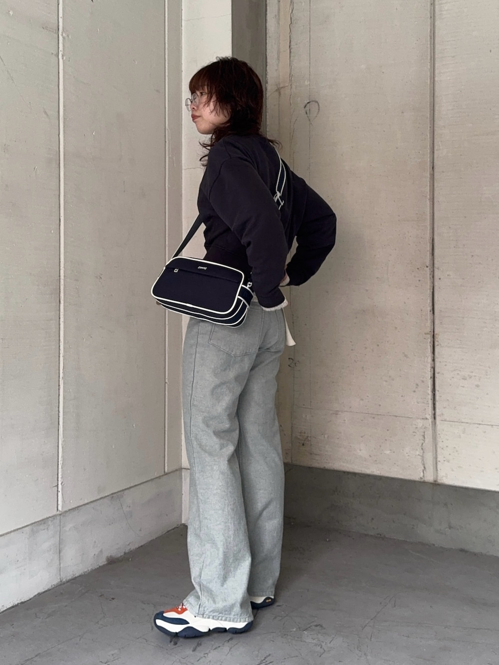 ブルー系のデニムジャケット、ブルー系のデニムパンツ、ホワイト系のスニーカーを着用したレディースの冬コーディネートの2枚目の写真