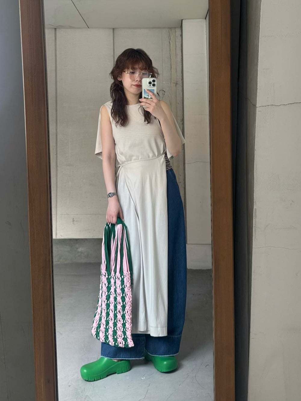 ホワイト系のワンピース、ブルー系のデニムパンツ、グリーン系のスリッポンを着用したレディースの夏コーディネートの4枚目の写真