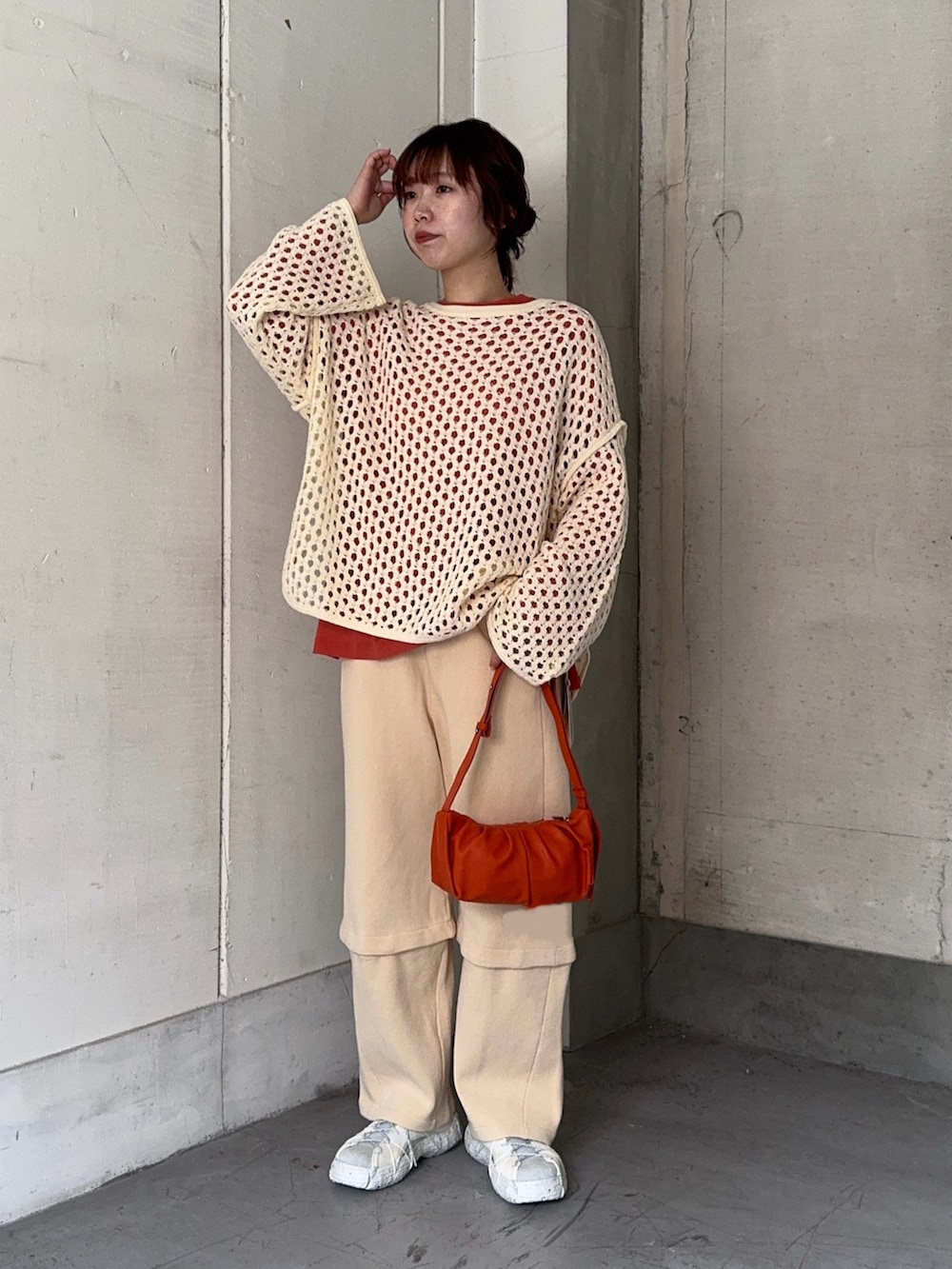 オレンジ系のTシャツ/カットソー、ホワイト系のその他パンツ、ホワイト系のスニーカーを着用したレディースの冬コーディネートの4枚目の写真