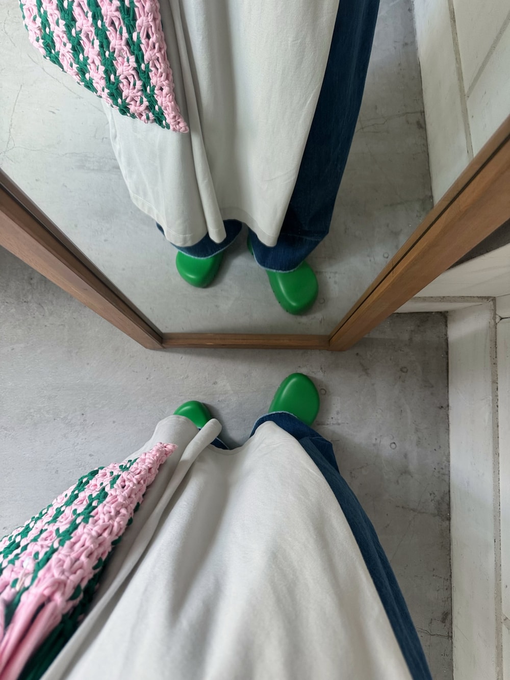 ホワイト系のワンピース、ブルー系のデニムパンツ、グリーン系のスリッポンを着用したレディースの夏コーディネートの3枚目の写真