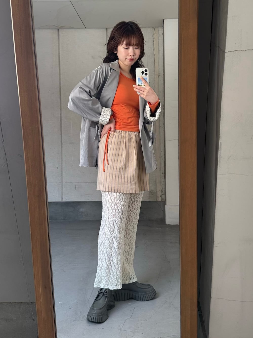 オレンジ系のその他パンツ、オレンジ系のTシャツ/カットソー、グレー系のその他アウターを着用したレディースの冬コーディネートの2枚目の写真