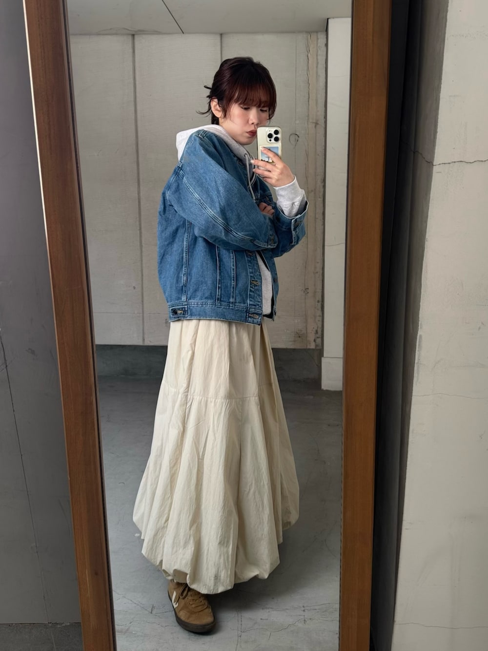 ブルー系のデニムジャケット、ベージュ系のショルダーバッグ、その他のパーカーを着用したレディースの冬コーディネートの5枚目の写真